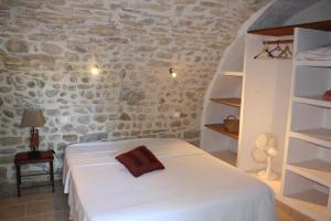 Un dormitorio con una cama y una pared de piedra. en Grand gîte Ardèche L'Avventura, en Grospierres
