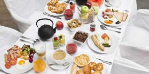 una mesa llena de alimentos para el desayuno en una mesa blanca en Le Bastidon de CUCURON, en Cucuron