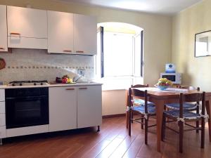 a kitchen with white cabinets and a table with a tableablish at House Blue Sky by Holiday World in Genoa