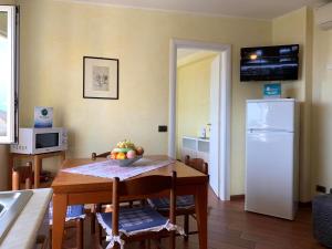 a kitchen with a table and a white refrigerator at House Blue Sky by Holiday World in Genoa