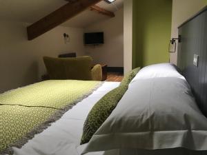 a bedroom with a white bed with a chair at Plasglasgwm in Betws-y-coed