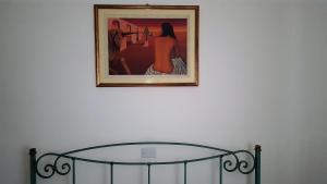 een schilderij op een muur met een glazen tafel bij IGGH Il Glicine Guest House in San Benedetto del Tronto