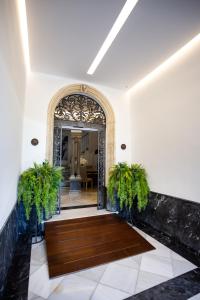 an entry way with a wooden door and plants at Plazuela del Carbón Suites in Cádiz