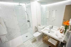 a white bathroom with a sink and a shower at Plazuela del Carbón Suites in Cádiz