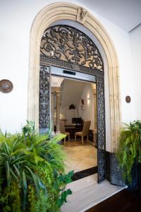 an ornate doorway into a living room with plants at Plazuela del Carbón Suites in Cádiz