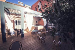 a patio with chairs and a table on a deck at The Old Hotel Ravel Centre in Clermont-Ferrand