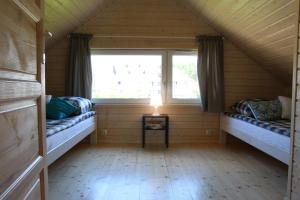two beds in a room with two windows at Jachtowa Park in Grzybowo