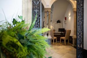 a hallway with a desk and chairs in a building at Plazuela del Carbón Suites in Cádiz