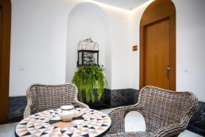 two wicker chairs and a table in a room at Plazuela del Carbón Suites in Cádiz
