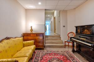 a living room with a couch and a piano at Hotel Aurora in Cimego