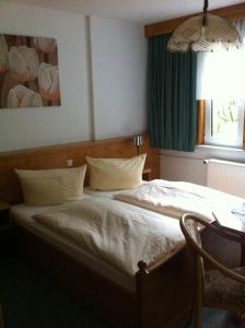 1 dormitorio con 1 cama con cortina verde y ventana en Pension Tannenrausch, en Friedrichroda