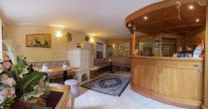 a large living room with a table and a fireplace at Hotel El Paso in Fai della Paganella