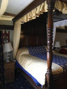 a bed that has a canopy over it at The Chequers Inn in Smarden