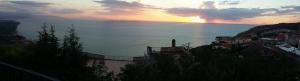 ニコーテラ・マリーナにあるHotel Ristorante Antica Marinaの遠くに太陽が見える海