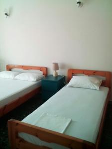 ein Schlafzimmer mit 2 Betten und einer Lampe auf einem Nachttisch in der Unterkunft Antonys Apartment Sea View II (1st floor) in Tiros