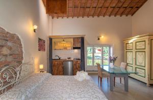 een slaapkamer met een bed en een tafel en een keuken bij La Mandolata dei Poeti Apartaments in Lucca