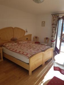 a bedroom with a large wooden bed in a room at Agritur Coryletum in Coredo