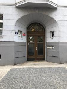 budynek z brązowymi drzwiami i ceglanym chodnikiem w obiekcie Apartment Slavikova 11 w Pradze