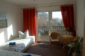 Schlafzimmer mit einem Bett, einem Fenster und einem Tisch in der Unterkunft Haus am Haff in Karnin