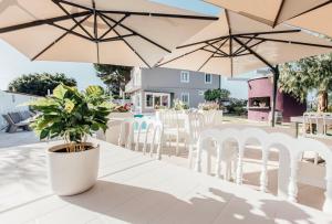 a table with white chairs and umbrellas at Suite 106 in Vasto