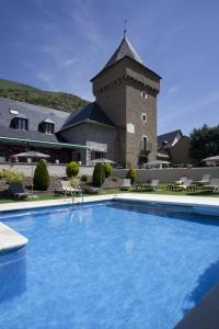 a swimming pool in front of a building with a tower at Parador de Artíes in Arties