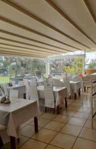 un restaurant avec des tables blanches et des chaises blanches dans l'établissement Saint George Sithonia, à Neos Marmaras
