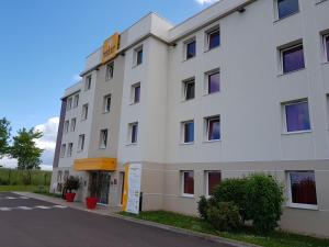 a white building with a sign on the side of it at Premiere Classe Sens Nord- Saint Clément in Sens