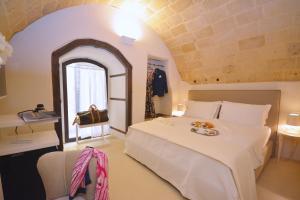 a bedroom with a large white bed and a window at I Bastioni San Domenico - Boutique Hotel in Gallipoli