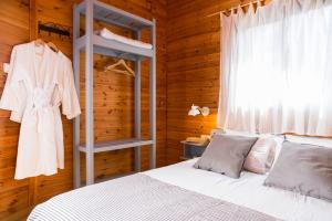 a bedroom with a white bed and a wooden wall at Naomi's place הבית של נעמי in Moshav Ramot