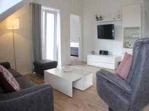 a living room with two chairs and a tv at Sonnengarten 10 - Ruhepol in Kellenhusen