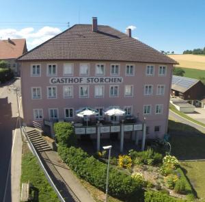 瓦爾茨胡特田根的住宿－Gasthaus Storchen，粉红色的建筑,前面有餐厅