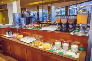 una línea de buffet con muchos alimentos y bebidas diferentes en Hotel Las Rocas en Mar del Plata