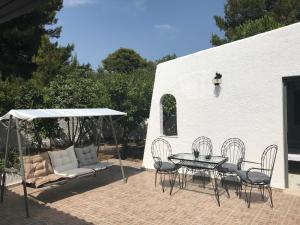 a patio with a table and chairs and an umbrella at Athens Airport, Seaside house in Artemida