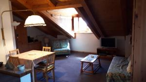 a living room with a table and a tv at Mansarda - La Thuile Frazione Buic in La Thuile