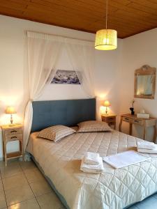 a bedroom with a large bed with a canopy at Emmanouil airport beach apartment in Karteros