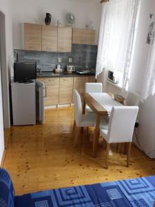 a kitchen with a wooden table and white chairs at Apartment Anna in Český Dub