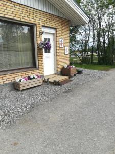 Una puerta principal de una casa con flores. en Köpsintie 4 en Pyhäjärvi