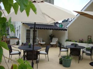 a patio with tables and chairs and an umbrella at BlancNoir Bed & Breakfast in Baltimore