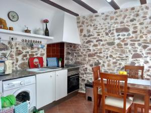 a kitchen with a washer and dryer in a stone wall at Rosita Casa Rural in Estivella