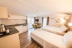 a hotel room with two beds and a kitchen at dekatria rooms&aparts in Kas +55 photos