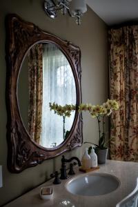 lavabo en el baño con espejo grande en la pared en Maplehurst Manor Bed and Breakfast en Dorchester