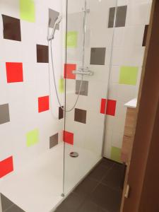 a shower in a bathroom with colorful tiles at Hotel Les Gravades Ussel in Ussel