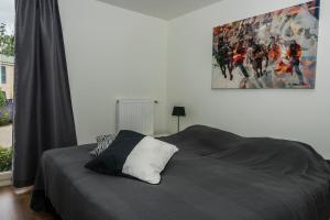 a bedroom with a bed and a painting on the wall at Chaletparc Krabbenkreek Zeeland - Chalet 94 in Sint Annaland