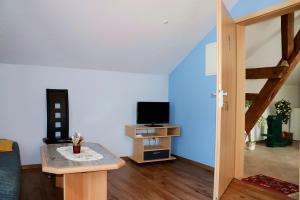 a living room with a television and a table at Pension Kuhn in Klietz