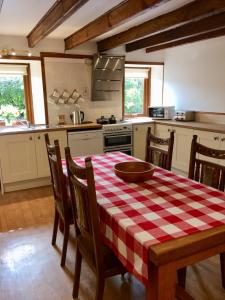 a kitchen with a table with a red and white checkered table cloth at Lower Thura House in Wick