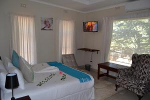 Un pat sau paturi într-o cameră la Chobe Sunset Chalets