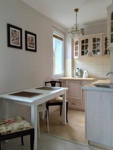 een keuken met een witte tafel en stoelen. bij Studio Sopot in Sopot