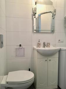 een witte badkamer met een toilet en een wastafel bij Studio Sopot in Sopot