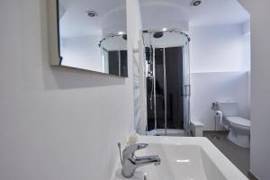 Baño blanco con lavabo y espejo en Appartement T3 Rdc au calme, 6 couchages, en Le Pin