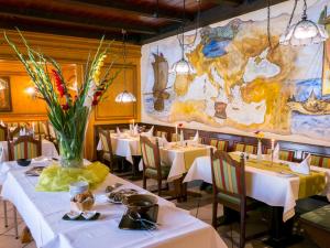 Hotel Restaurant Schiff في كابل غرافنهاوسن: مطعم بطاولات وكراسي بيضاء وخريطة على الحائط